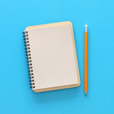 mavi arka plan üzerinde boş not defteri. mockup için hazır. Üst görünüm düz yatıyordu