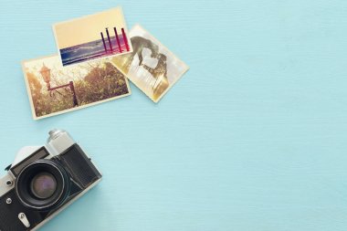 Ahşap masa nın üzerinde kameranın yanında boş fotoğrafların üst görünümü. seyahat konsepti. alay etmeye hazır