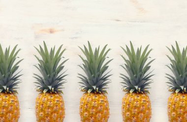 Beyaz ahşap arka plan üzerinde olgun ananas. Plaj ve tropikal tema. Üstte görüntü