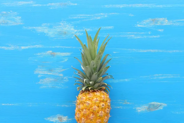 Dojrzałe ananasy na niebieskim tle drewnianym. Plaża i tropikalny motyw. Widok z góry — Zdjęcie stockowe