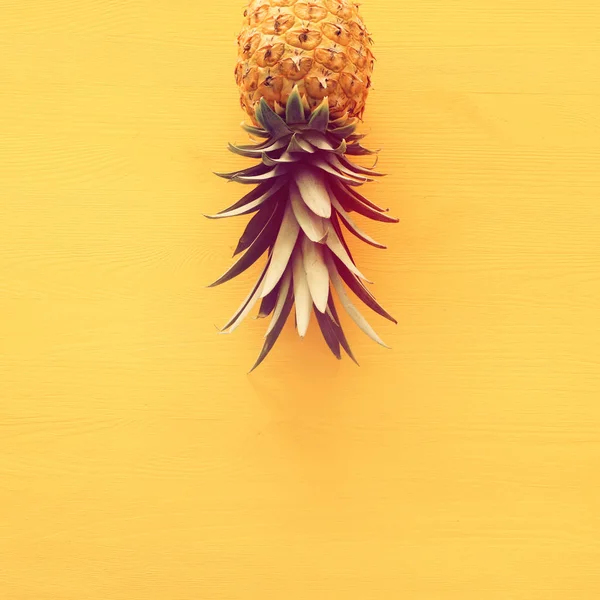 Ripe pineapple over yellow wooden background. Beach and tropical theme. Top view — Stock Photo, Image