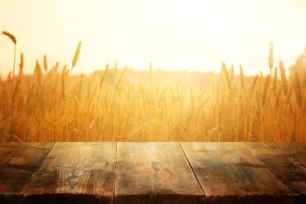 夕暮れ時の小麦畑の前の木の板。プロダクトディスプレイモンタージュの準備 — ストック写真