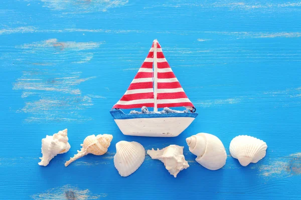 Деревянная винтажная лодка и ракушки на голубом фоне — стоковое фото