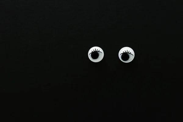 Par googly olhos sobre fundo preto — Fotografia de Stock