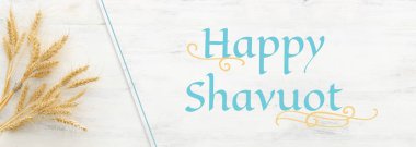 Beyaz ahşap zemin üzerinde buğday mahsullerinin üst görüntüsü. Yahudi bayramının sembolleri - Shavuot