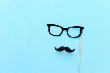 Babalar günü konsepti. Hipster gözlük ve mavi ahşap arka plan üzerinde bıyık. üst görünüm, düz yatıyordu