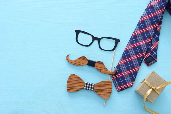 Father's day concept. Hipster glasses, goft box tie and funny moustache over blue wooden background. top view, flat lay — Stock Photo, Image