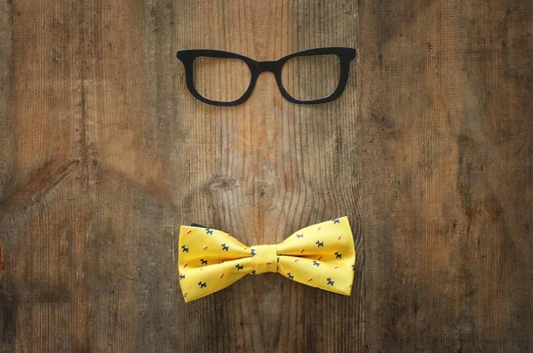 Fars dags koncept. Hipster glasögon och fluga på trä bakgrund. övre vy, Flat Lay — Stockfoto