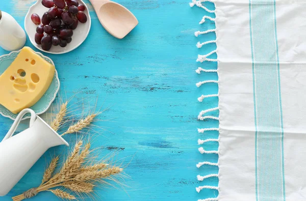 Foto von oben mit Milchprodukten vor blauem Holzhintergrund. Symbole des jüdischen Feiertags - Shavuot — Stockfoto