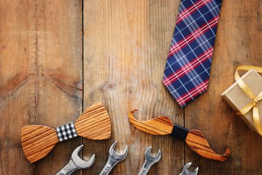 Babalar günü konsepti. hediye kutusu, kravat ve ahşap arka plan üzerinde komik bıyık. üst görünüm, düz yatıyordu