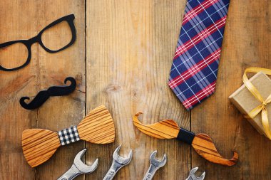 Babalar günü konsepti. Hipster gözlük, hediye kutusu, kravat ve ahşap arka plan üzerinde komik bıyık. üst görünüm, düz yatıyordu