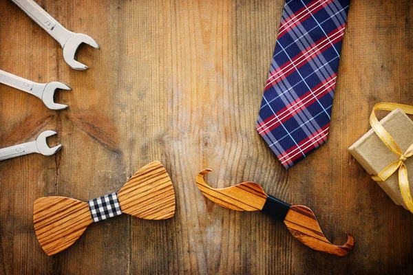 Babalar günü konsepti. hediye kutusu, kravat ve ahşap arka plan üzerinde komik bıyık. üst görünüm, düz yatıyordu
