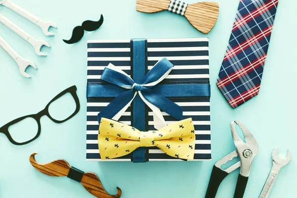 Father's day concept. Hipster glasses, gift box, tie and funny moustache over wooden background. top view, flat lay — Stock Photo, Image