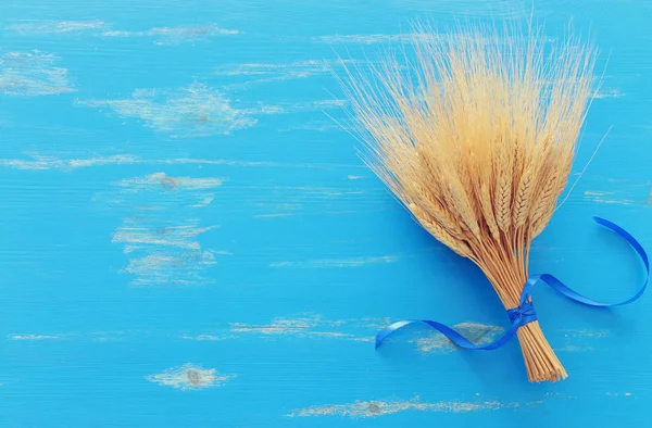 Mavi ahşap zemin üzerinde buğday mahsullerinin üst görüntüsü. Yahudi bayramının sembolleri - Shavuot — Stok fotoğraf