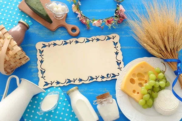 Horní pohled fotografie mléčných výrobků na modrém dřevěném pozadí. Symboly židovské dovolené - Shavuot — Stock fotografie