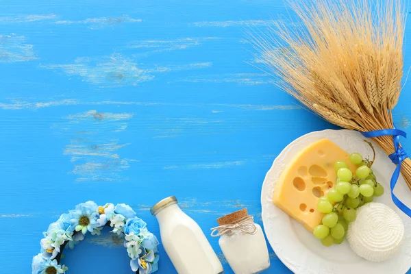 青い木製の背景に乳製品のトップビューの写真。ユダヤ教の祝日のシンボル- Shavuot — ストック写真
