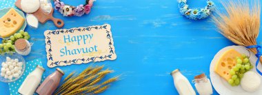 Süt ürünlerinin mavi ahşap arka plandaki en iyi görüntüsü. Yahudi bayramının sembolleri - Shavuot