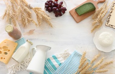 Süt ürünlerinin beyaz ahşap zemin üzerindeki en iyi görüntüsü. Yahudi bayramının sembolleri - Shavuot