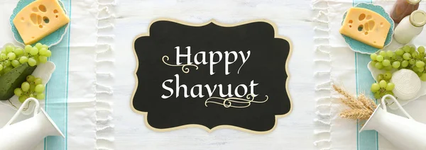 Süt ürünlerinin beyaz ahşap zemin üzerindeki en iyi görüntüsü. Yahudi bayramının sembolleri - Shavuot — Stok fotoğraf