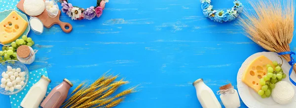 青い木製の背景に乳製品のトップビューの写真。ユダヤ教の祝日のシンボル- Shavuot — ストック写真