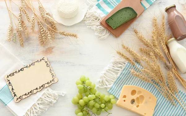 Foto von oben mit Milchprodukten vor weißem Holzhintergrund. Symbole des jüdischen Feiertags - Shavuot — Stockfoto