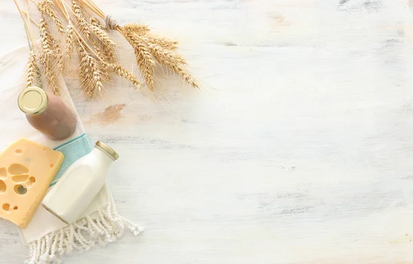 Foto von oben mit Milchprodukten vor weißem Holzhintergrund. Symbole des jüdischen Feiertags - Shavuot — Stockfoto