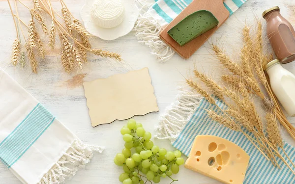 Foto von oben mit Milchprodukten vor weißem Holzhintergrund. Symbole des jüdischen Feiertags - Shavuot — Stockfoto