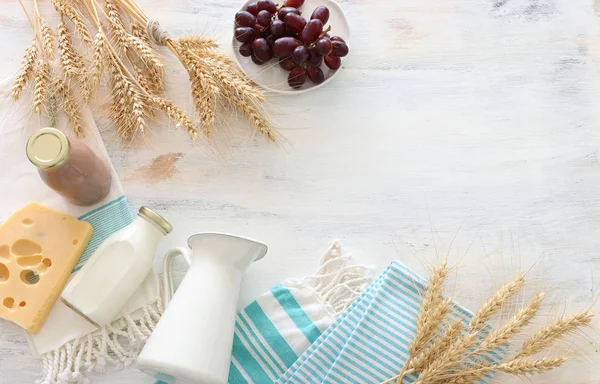 Foto von oben mit Milchprodukten vor weißem Holzhintergrund. Symbole des jüdischen Feiertags - Shavuot — Stockfoto