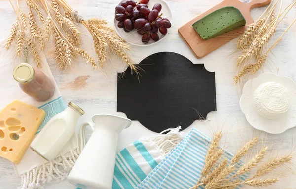 Foto von oben mit Milchprodukten vor weißem Holzhintergrund. Symbole des jüdischen Feiertags - Shavuot — Stockfoto