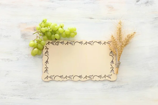 在白色木制背景上查看小麦作物和绿色葡萄。犹太节日的象征 - 沙武特 — 图库照片