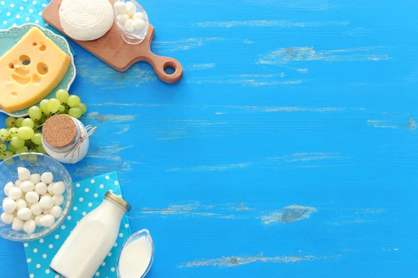 Foto von oben mit Milchprodukten vor blauem Holzhintergrund. Symbole des jüdischen Feiertags - Shavuot — Stockfoto