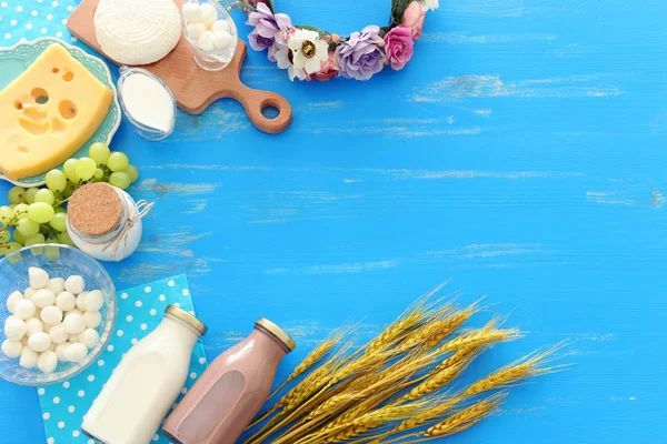 Foto von oben mit Milchprodukten vor blauem Holzhintergrund. Symbole des jüdischen Feiertags - Shavuot — Stockfoto