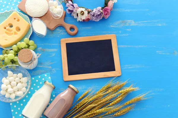 Foto von oben mit Milchprodukten vor blauem Holzhintergrund. Symbole des jüdischen Feiertags - Shavuot — Stockfoto