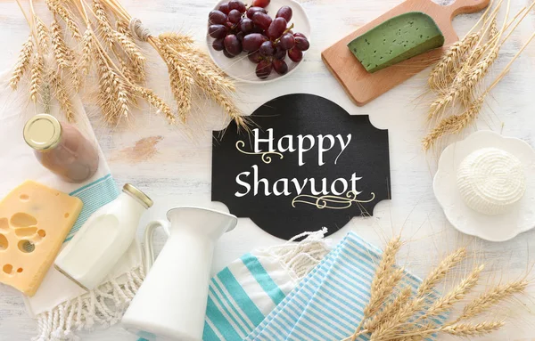 Foto von oben mit Milchprodukten vor weißem Holzhintergrund. Symbole des jüdischen Feiertags - Shavuot — Stockfoto