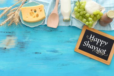 Süt ürünlerinin mavi ahşap arka plandaki en iyi görüntüsü. Yahudi bayramının sembolleri - Shavuot