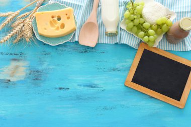 Süt ürünlerinin mavi ahşap arka plandaki en iyi görüntüsü. Yahudi bayramının sembolleri - Shavuot