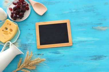 Süt ürünlerinin mavi ahşap arka plandaki en iyi görüntüsü. Yahudi bayramının sembolleri - Shavuot