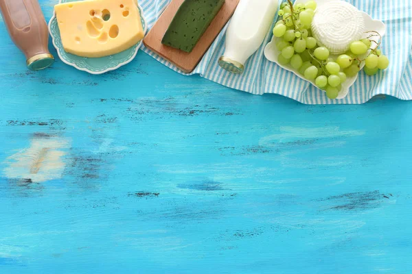 Vista superior de la foto de productos lácteos sobre fondo de madera azul. Símbolos de la fiesta judía - Shavuot — Foto de Stock