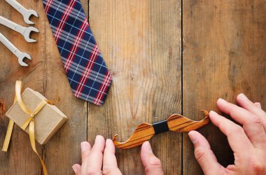 Babalar günü konsepti. hediye kutusu, kravat ve ahşap arka plan üzerinde komik bıyık. üst görünüm, düz yatıyordu