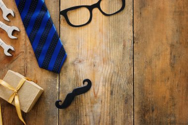 Babalar günü konsepti. hediye kutusu, kravat ve ahşap arka plan üzerinde komik bıyık. üst görünüm, düz yatıyordu