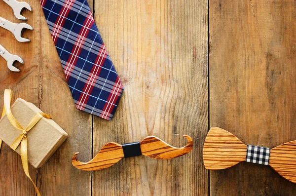 Conceito de dia do pai. Caixa de presente, gravata e bigode engraçado sobre fundo de madeira. vista superior, flat lay — Fotografia de Stock