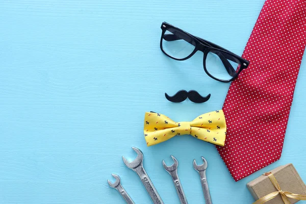 Conceito de dia do pai. Caixa de presente, gravata e bigode engraçado sobre fundo de madeira. vista superior, flat lay — Fotografia de Stock