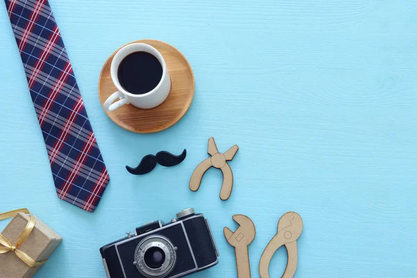 Le concept de la fête des pères. Coffret cadeau, cravate et drôle de moustache sur fond en bois. vue du dessus, plan plat — Photo