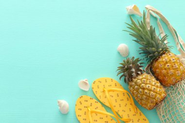 Pastel nane mavi ahşap arka plan üzerinde olgun ananas ve plaj deniz yaşam tarzı nesneleri. Tropikal yaz tatili konsepti