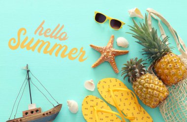 Pastel nane mavi ahşap arka plan üzerinde olgun ananas ve plaj deniz yaşam tarzı nesneleri. Tropikal yaz tatili konsepti