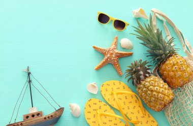Pastel nane mavi ahşap arka plan üzerinde olgun ananas ve plaj deniz yaşam tarzı nesneleri. Tropikal yaz tatili konsepti