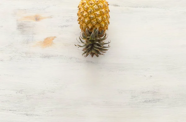 Ripe pineapple over white wooden background. Beach and tropical theme. Top view — Stock Photo, Image