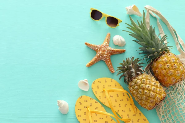 Dojrzałe ananasy i plaży morze stylu życia obiektów nad pastelowe mięty niebieskie tło drewniane. Koncepcja tropikalnych wakacji letnich — Zdjęcie stockowe
