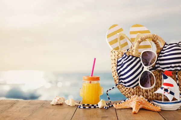 Concepto de vacaciones y verano con objetos de estilo de vida marina y bebida de fruta fresca sobre mesa de madera — Foto de Stock