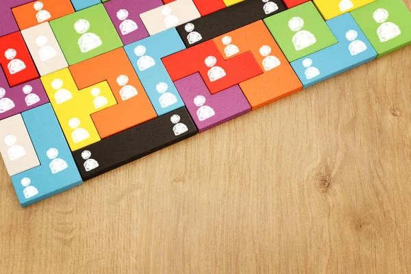 Obraz tangram puzzle bloki z ikonami ludzi nad drewnianym stole, zasobów ludzkich i koncepcji zarządzania — Zdjęcie stockowe
